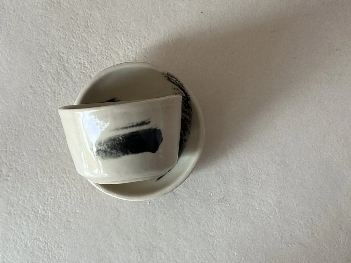 Eine weiße Wand mit einem runden, metallischen Lichtschalter und einem verstellbaren weißen Knauf.