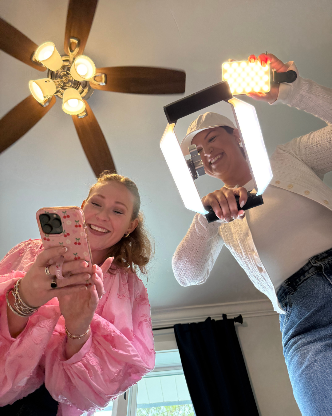 Lauren Womac and Nicole Merrell on a content shoot for Mac Made Creative with an iPhone and a ring light from above the photographer