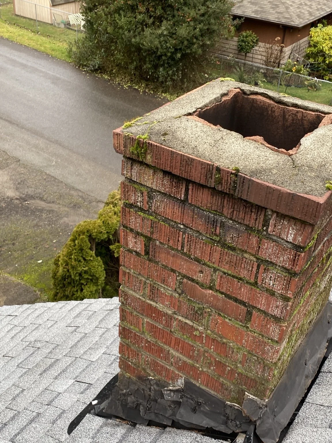 Deteriorated brick chimney and failing crown before masonry repair.