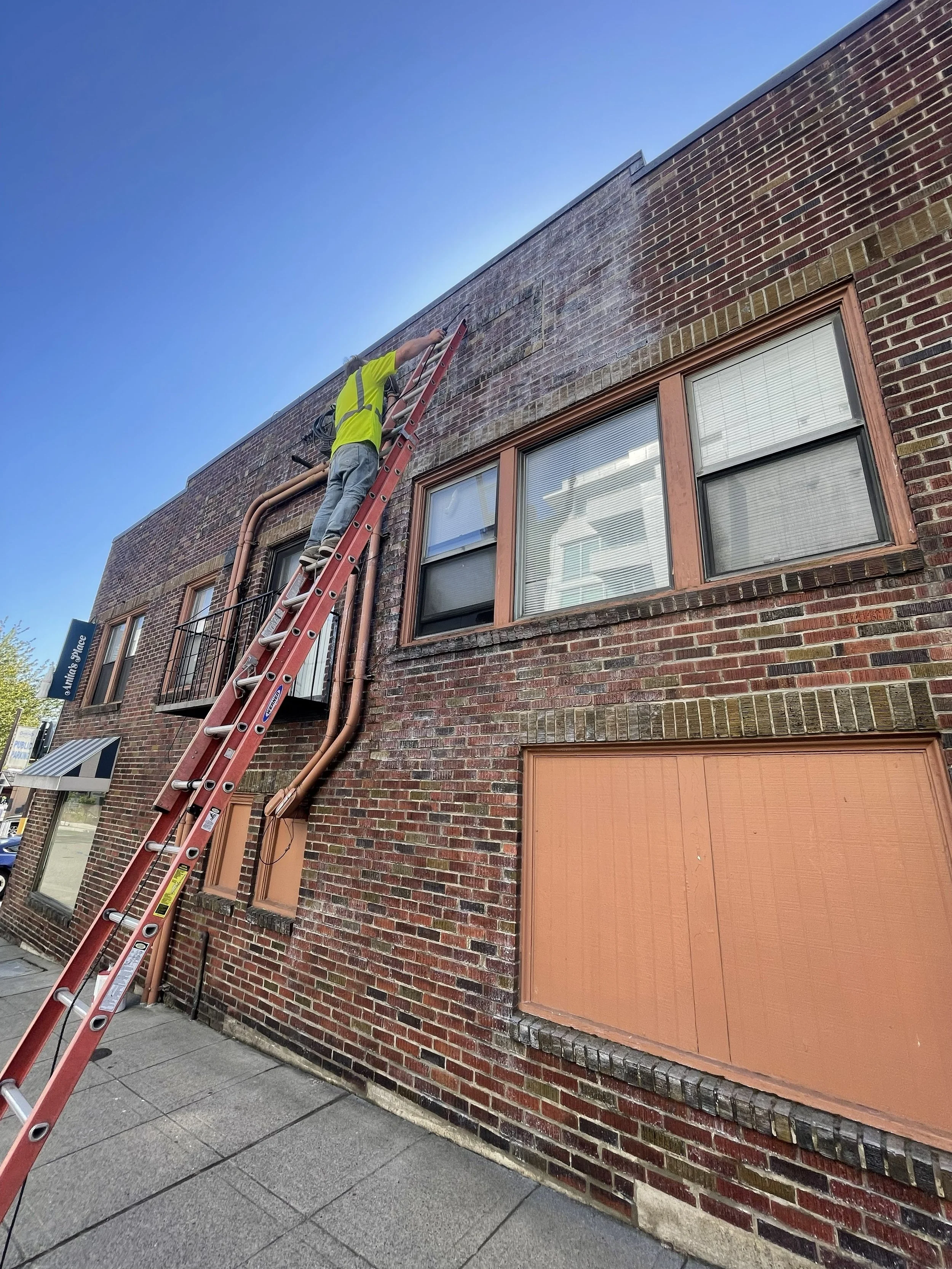 Brick masonry cleaning and restoration on a residential building.