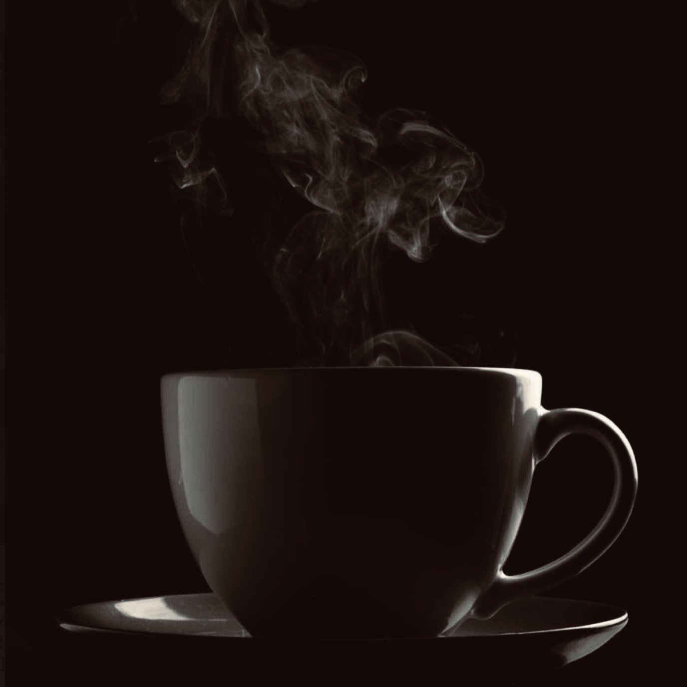 Steaming coffee cup on saucer with dark background