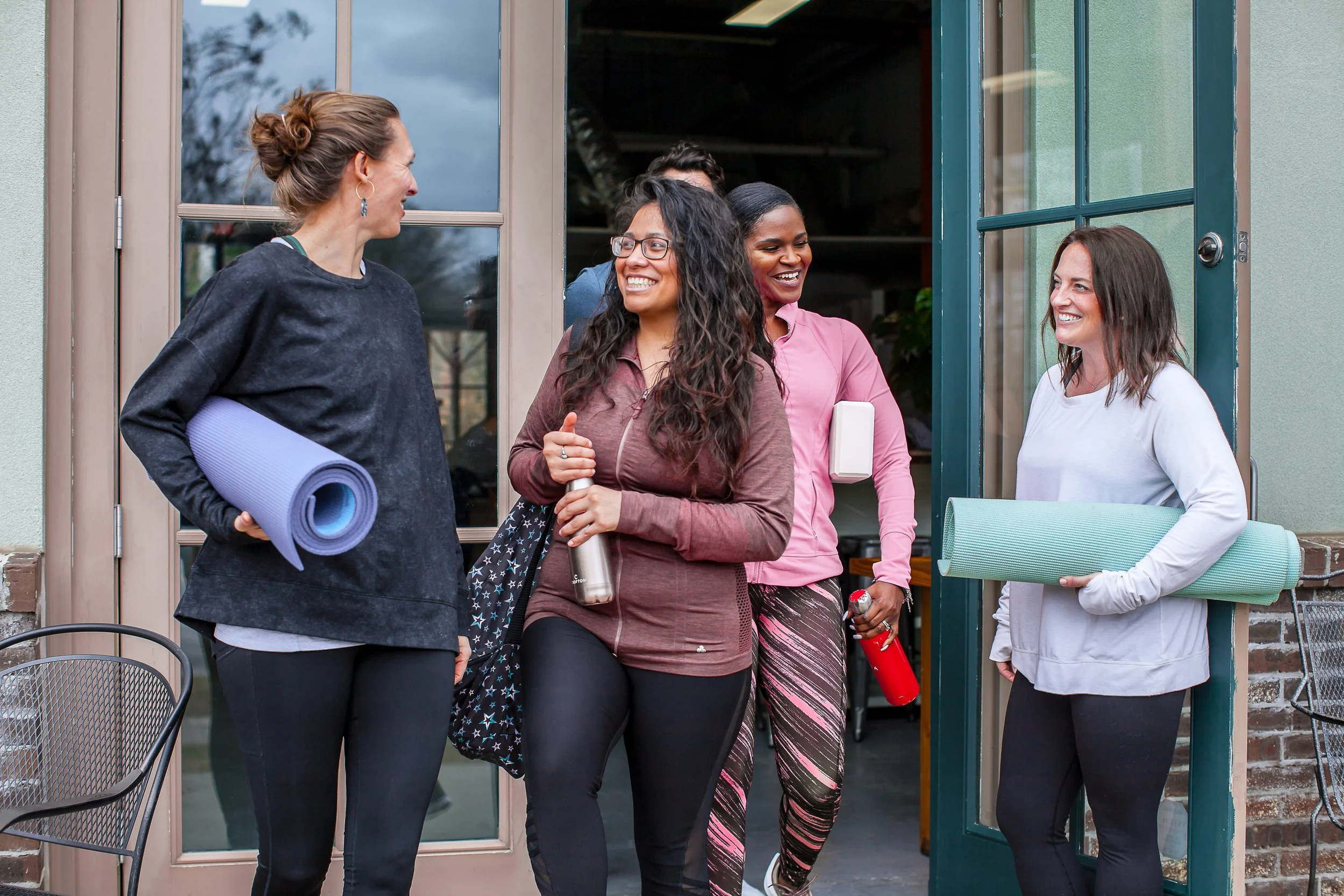 Group of women with yoga mats walking out of Haven Yoga studio in Atlanta.