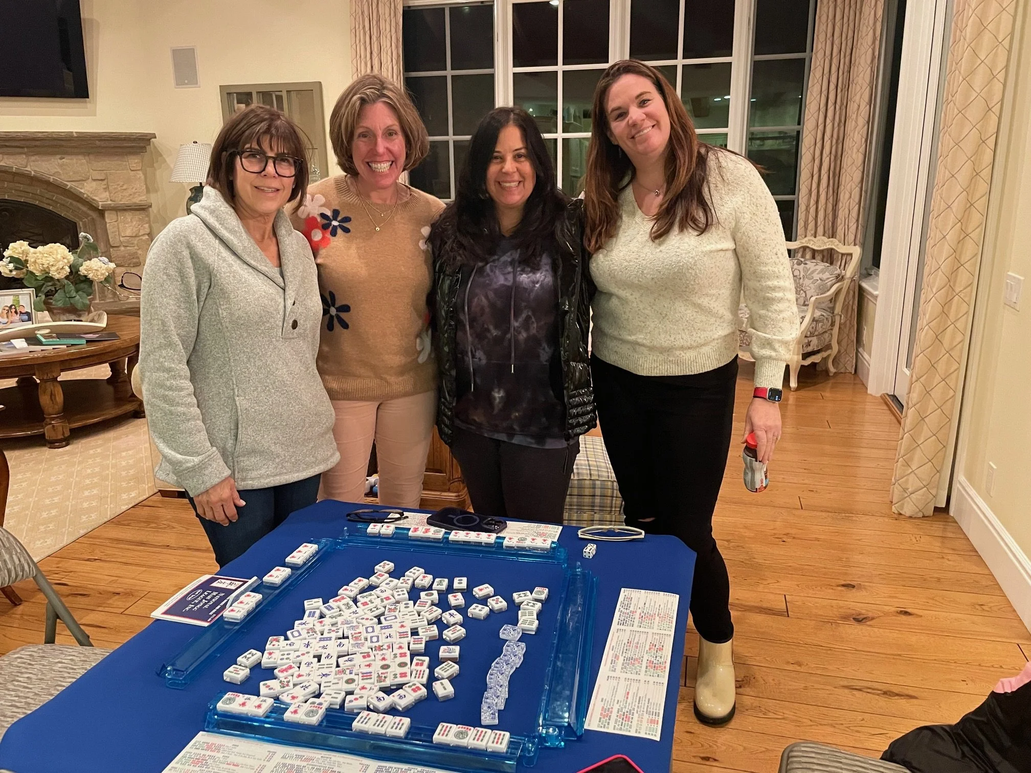 Beginner American Mahjong San Diego custom class. Students standing behind the mahjong table with tiles after class