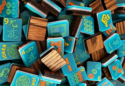 A pile of blue and wood-toned Mah Jongg tiles with various symbols and numbers.