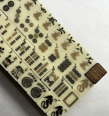 Close-up of Mahjong tiles with various designs including circles, characters, and dragons.