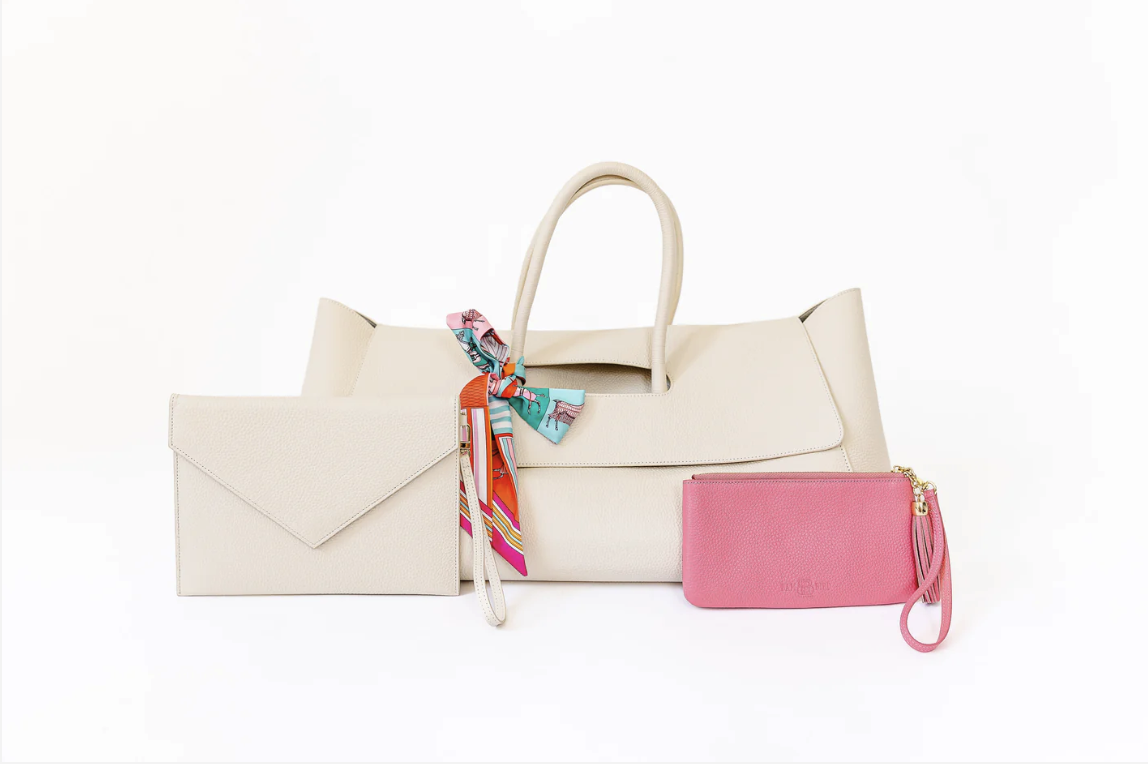 Cream handbag with colorful scarf, cream envelope clutch, and pink leather wristlet.