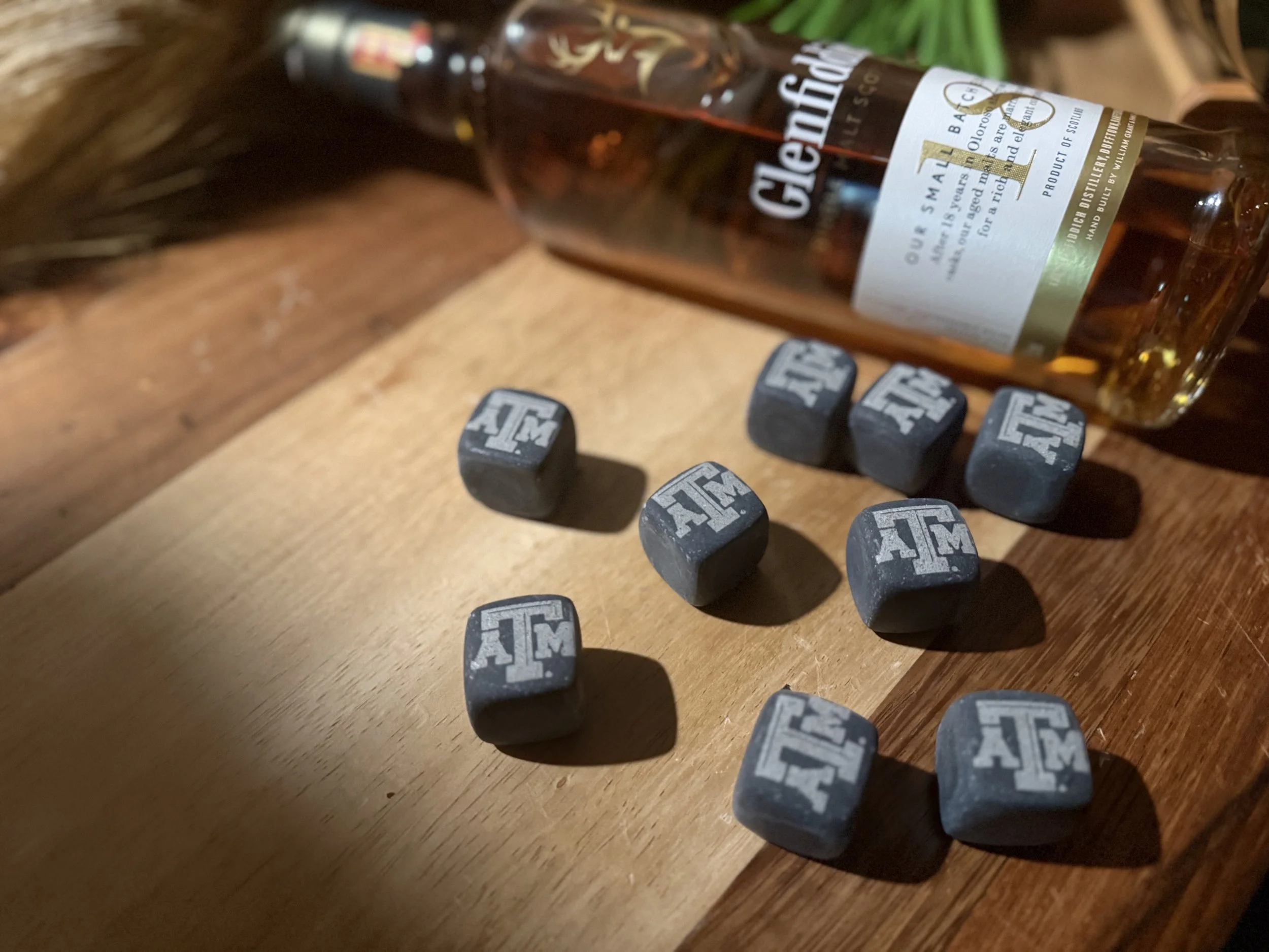 Backlit sign on a window that says "COFFEE" with warm hanging lights and reflections in the glass.