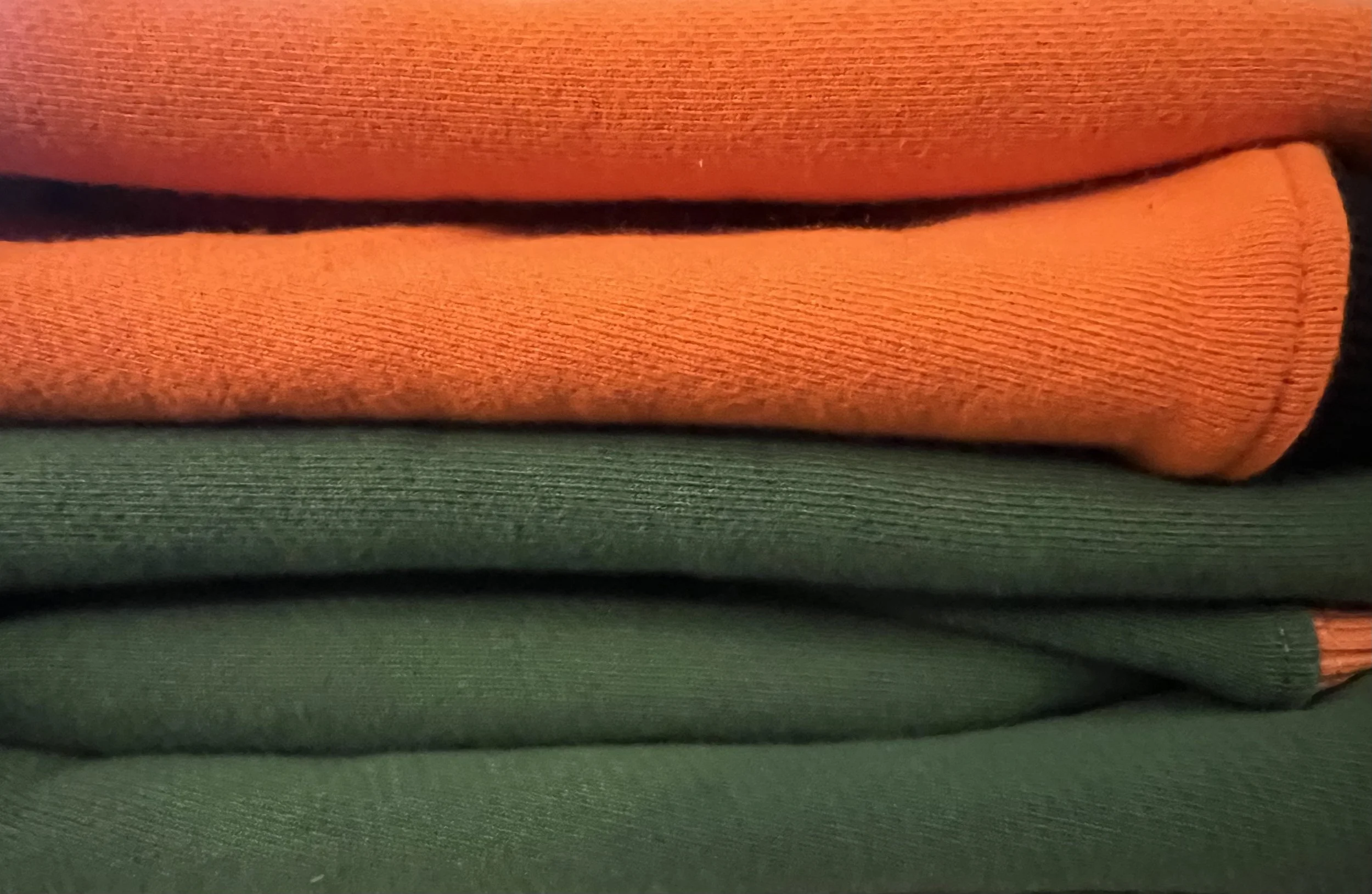 Stacked orange and green folded fabrics.