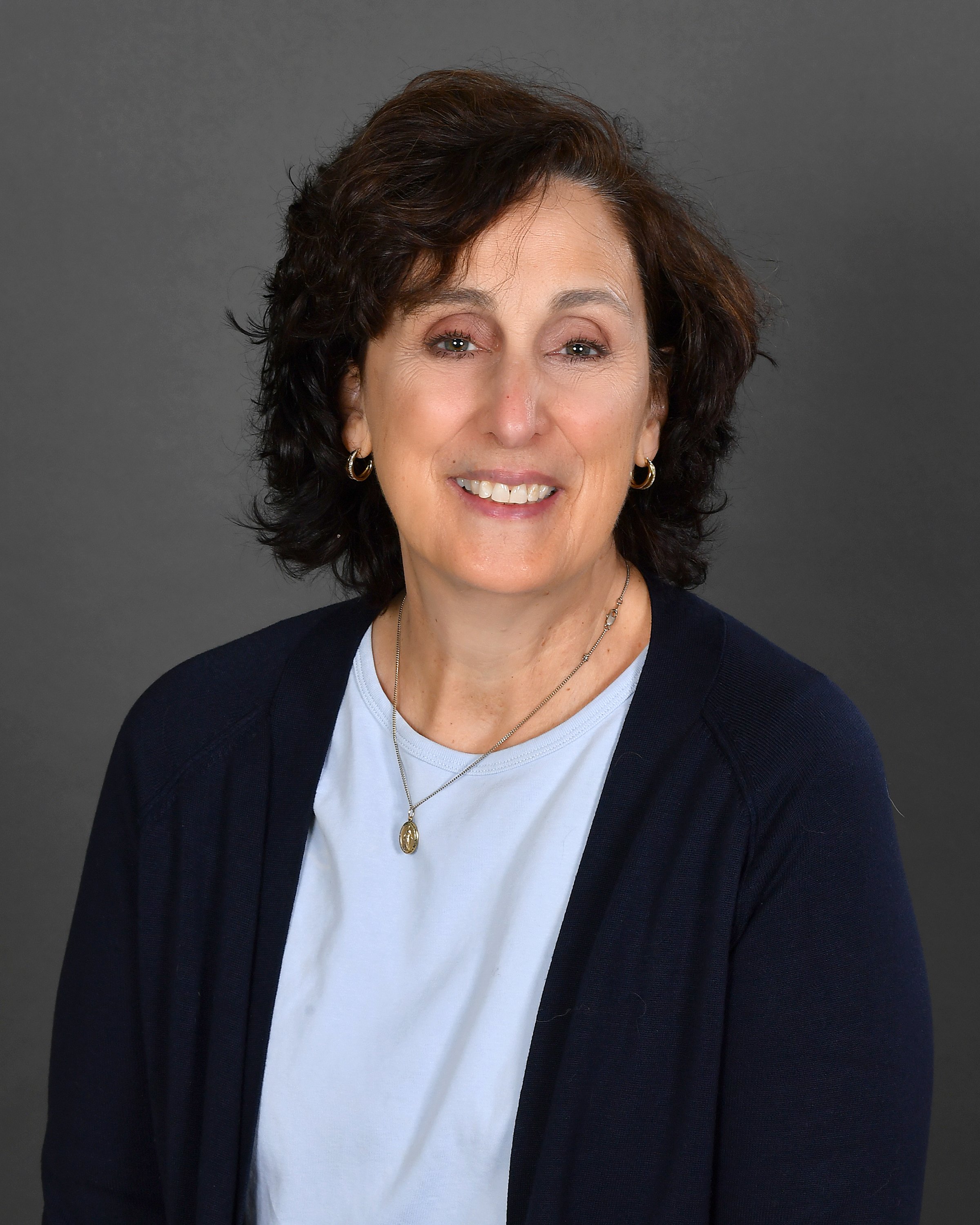 A graphic logo featuring a stylized side profile of a person's face with glasses, within a circular emblem. The emblem is surrounded by decorative gold laurel branches, and the words "CULTURA VITAE" are written below.