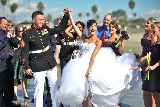 Bride and groom celebrating with wedding party on the beach