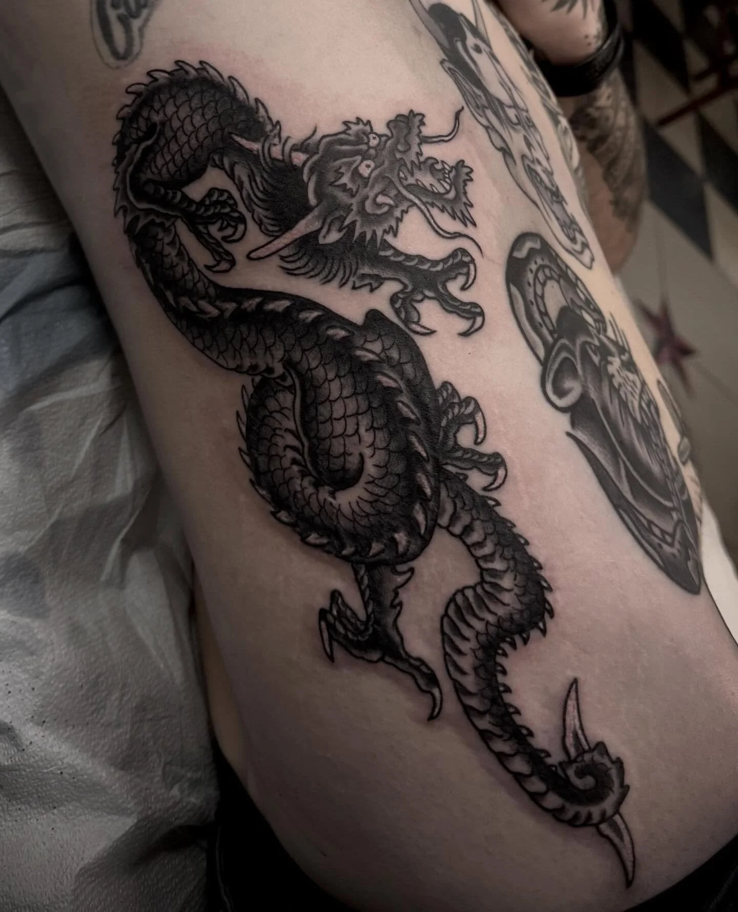 Done by @jacobyoungtattoo at #ElmStreetTattoo #DallasTexas #DeepEllum⁠
⁠
Contact: https://www.jacobyoungtattoo.com/book or DM⁠
⁠
Dragon sneakin up on a bad boy tat from the mad rooter @eyeball.tattoo -Visit the link in bio to book your next adventure