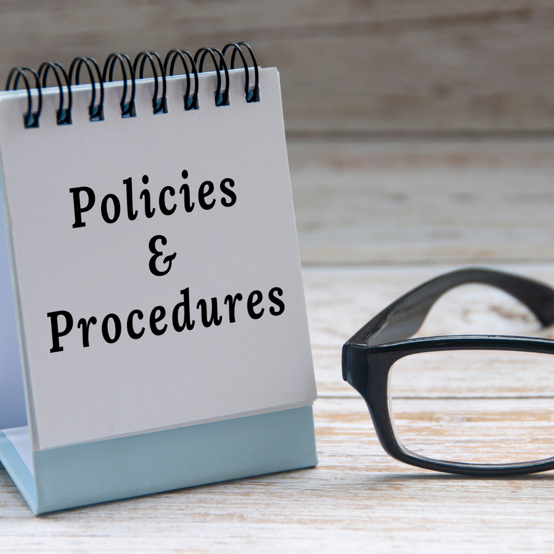 policies and procedures notepad with black reading glasses