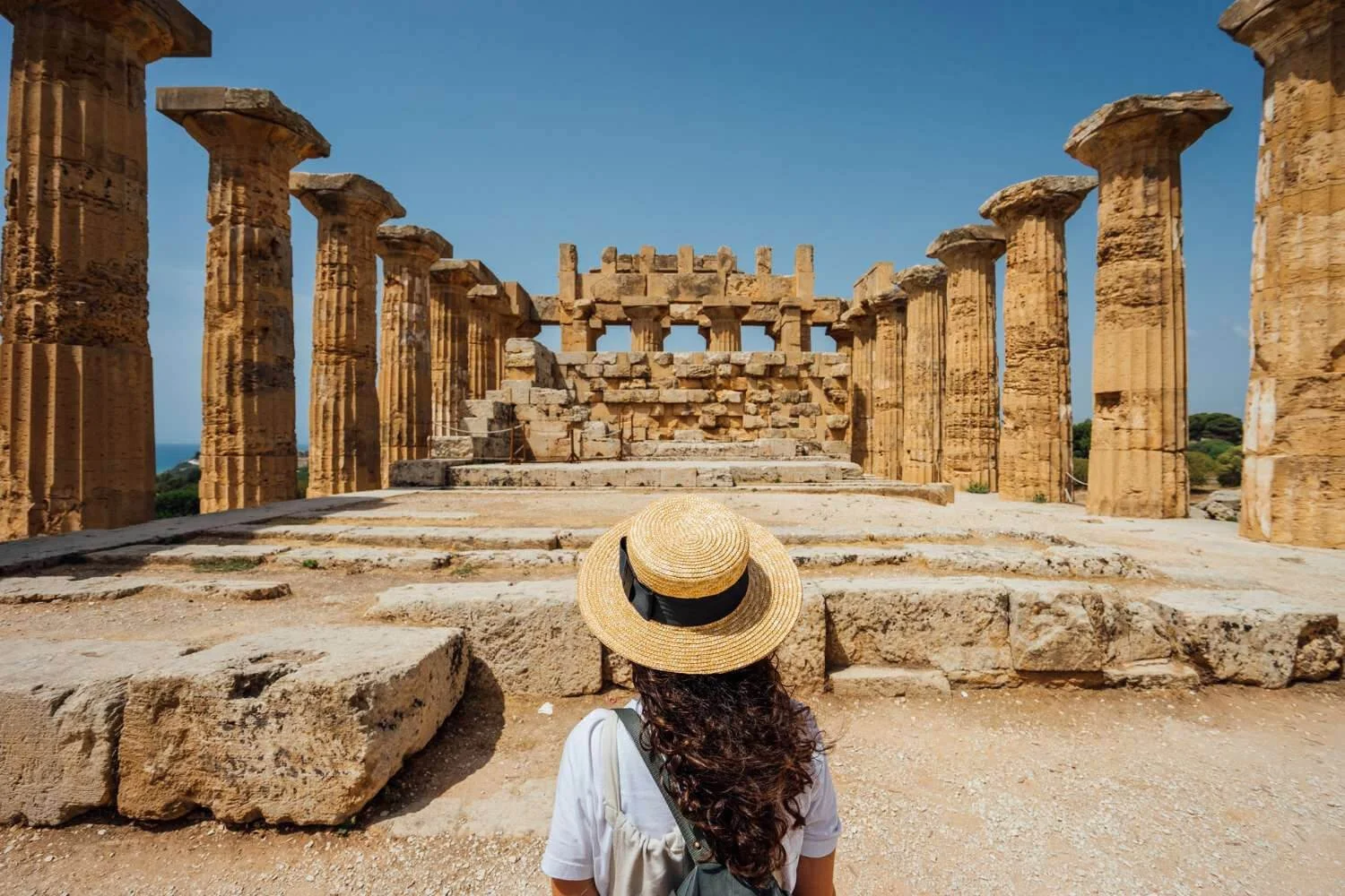 Woman wearing at hat while looking at the ruins of Valley of the Temples