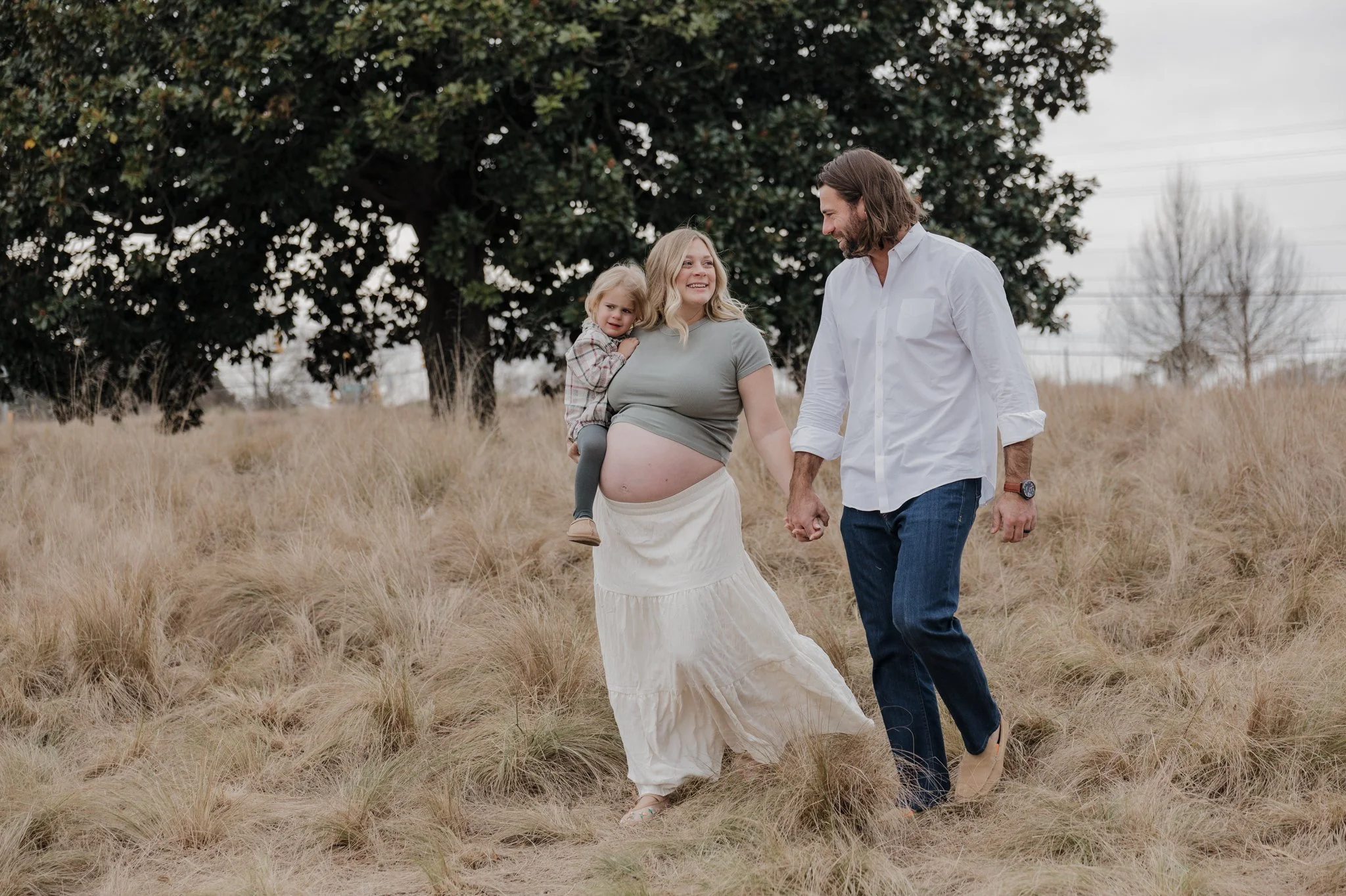  Raleigh maternity photographer capturing an expecting mother walking through the fields at NCMA Park. 
