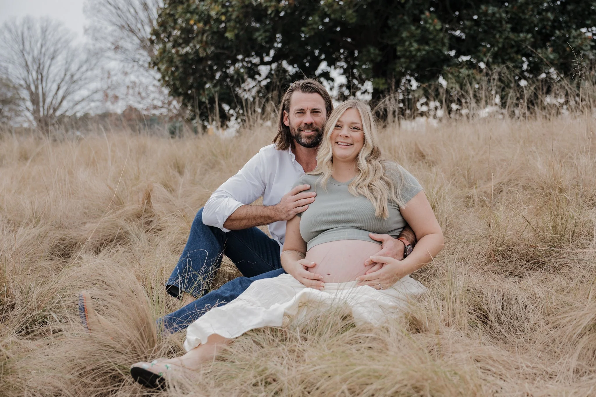 Timeless maternity session in a Raleigh field location, capturing the quiet moments of pregnancy