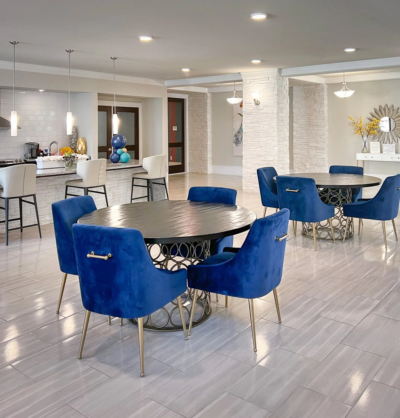 Commercial interior design dining seating area with blue velvet chairs with white walls and contemporary art in Houston Texas.

