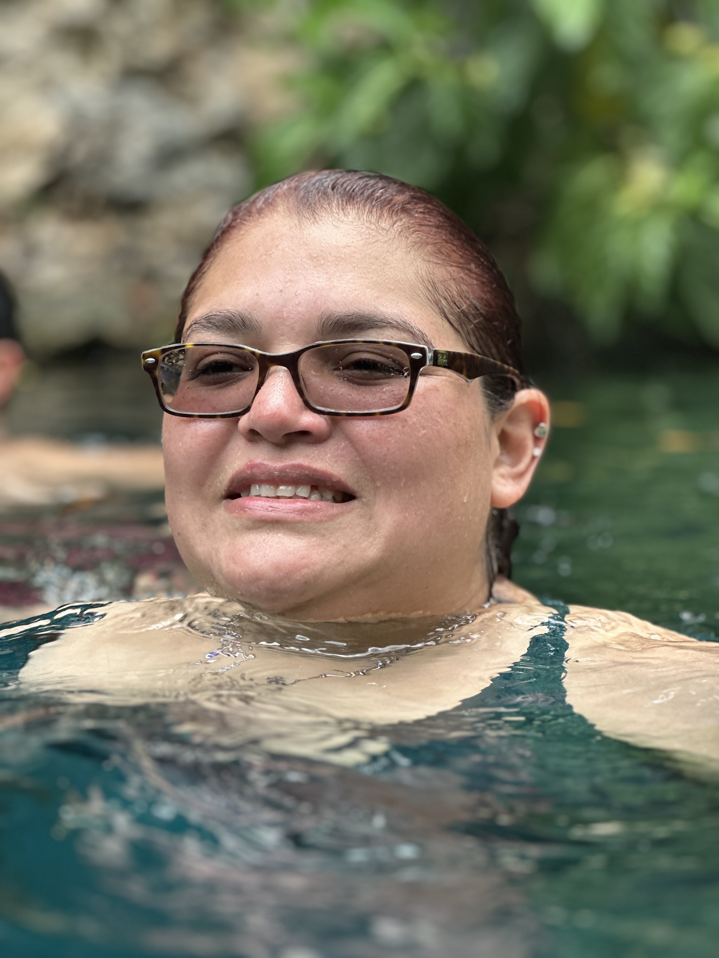 Person in water wearing glasses and a swimsuit