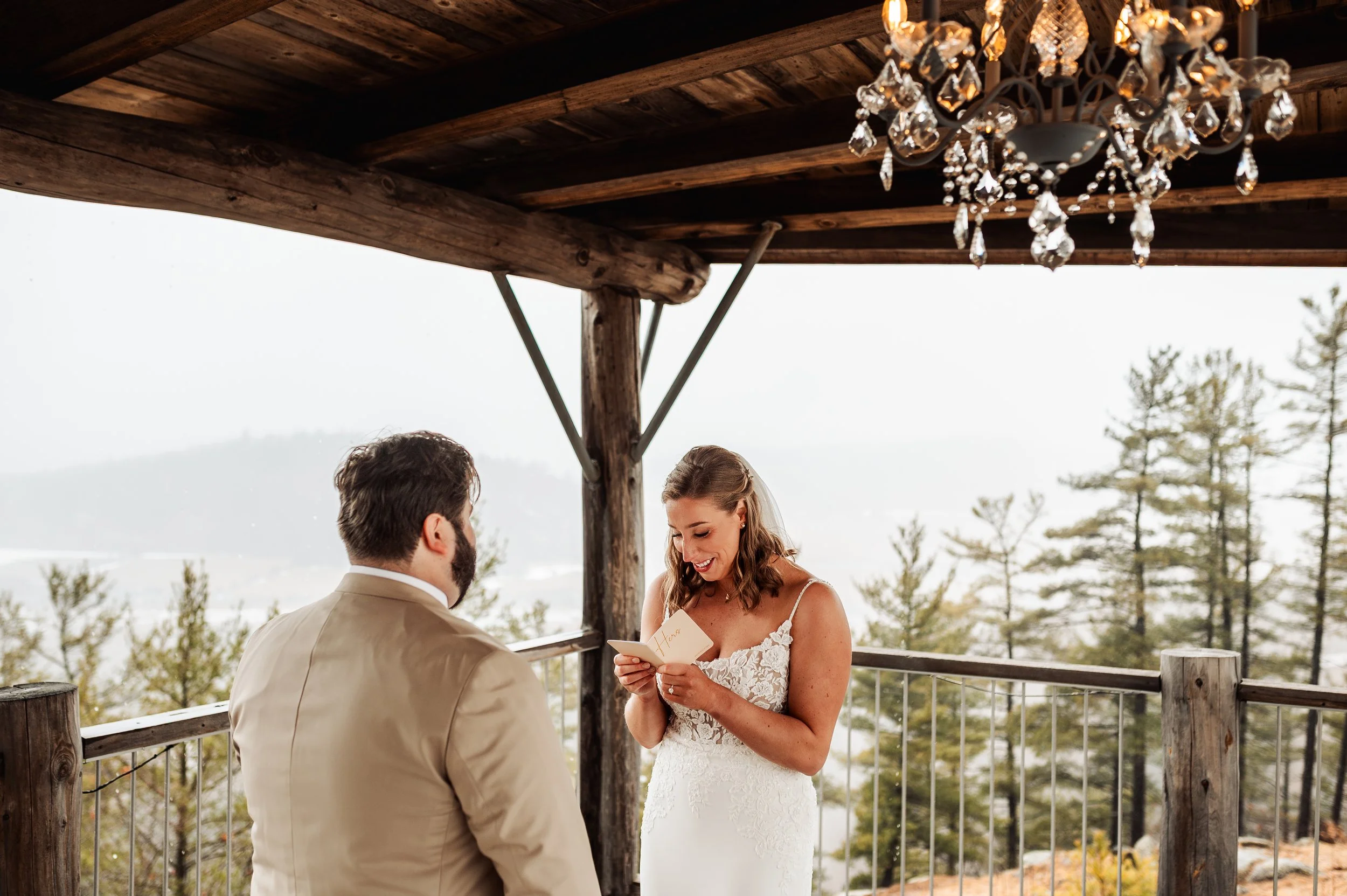 Bride reading her vows to the groom during a rainy first look at Le Belvédère in Wakefield, Quebec