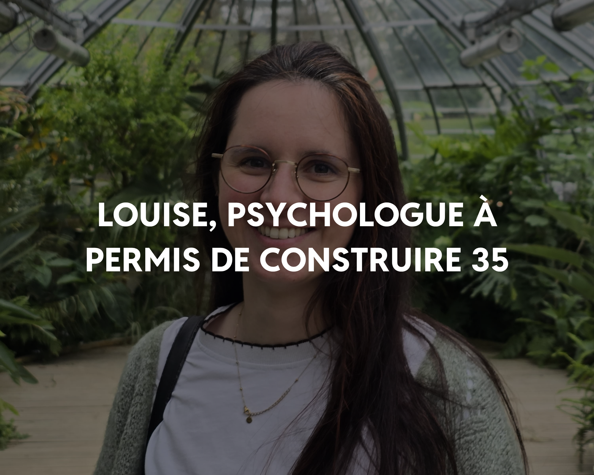Jeune femme souriante portant des lunettes et un collier, debout dans une serre remplie de plantes vertes.
