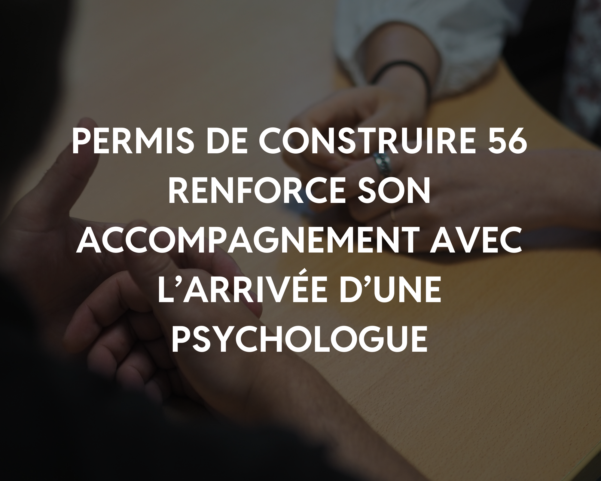 Une personne signant, avec une autre personne tenant sa main, lors d'une séance de thérapie ou de consultation, avec un fond de table en bois.