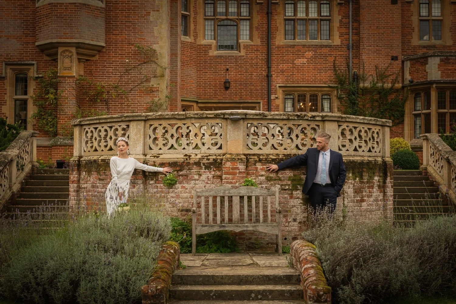 Bride and groom outside Lanwades Hall on the garden terrace surrounded by historic architecture
