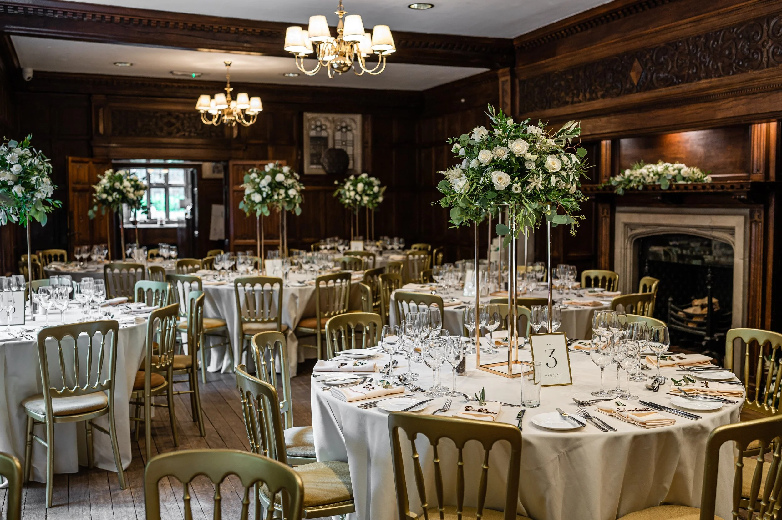 Elegant wedding reception setup with floral centrepieces in the Banqueting Hall at Lanwades Hall