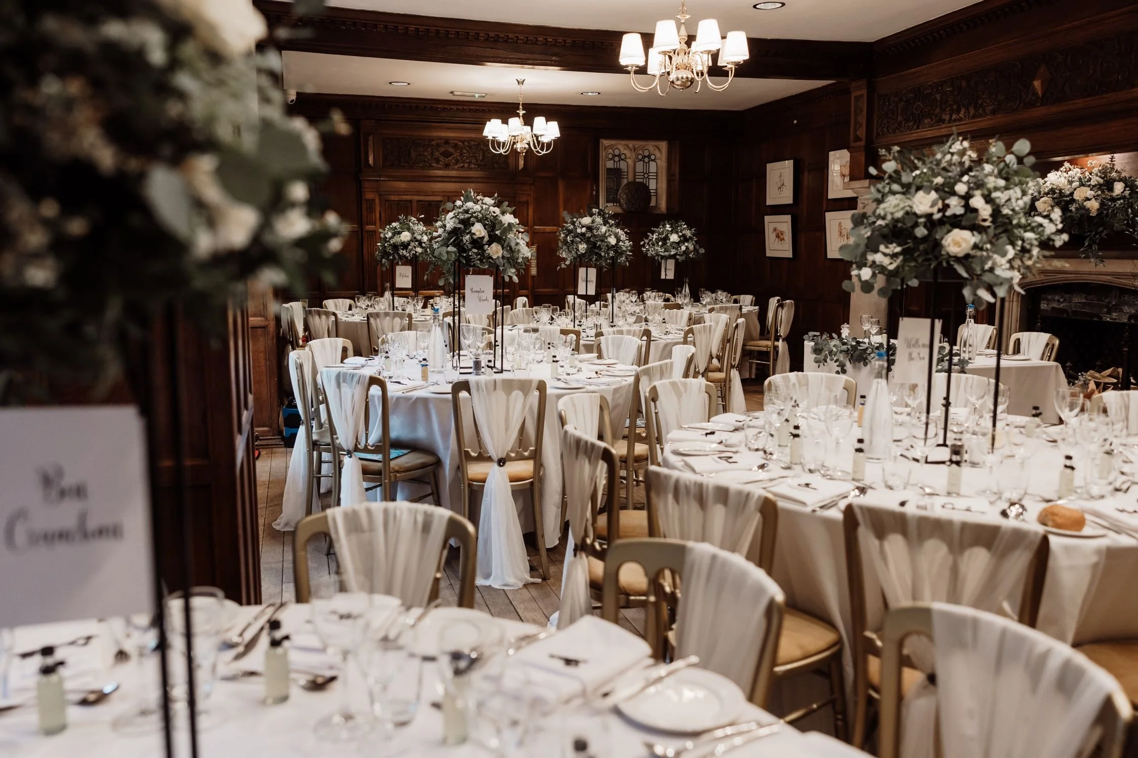 Luxury wedding reception dining room at Lanwades Hall, Suffolk, set with round tables, floral centrepieces and gold chairs for your special day.