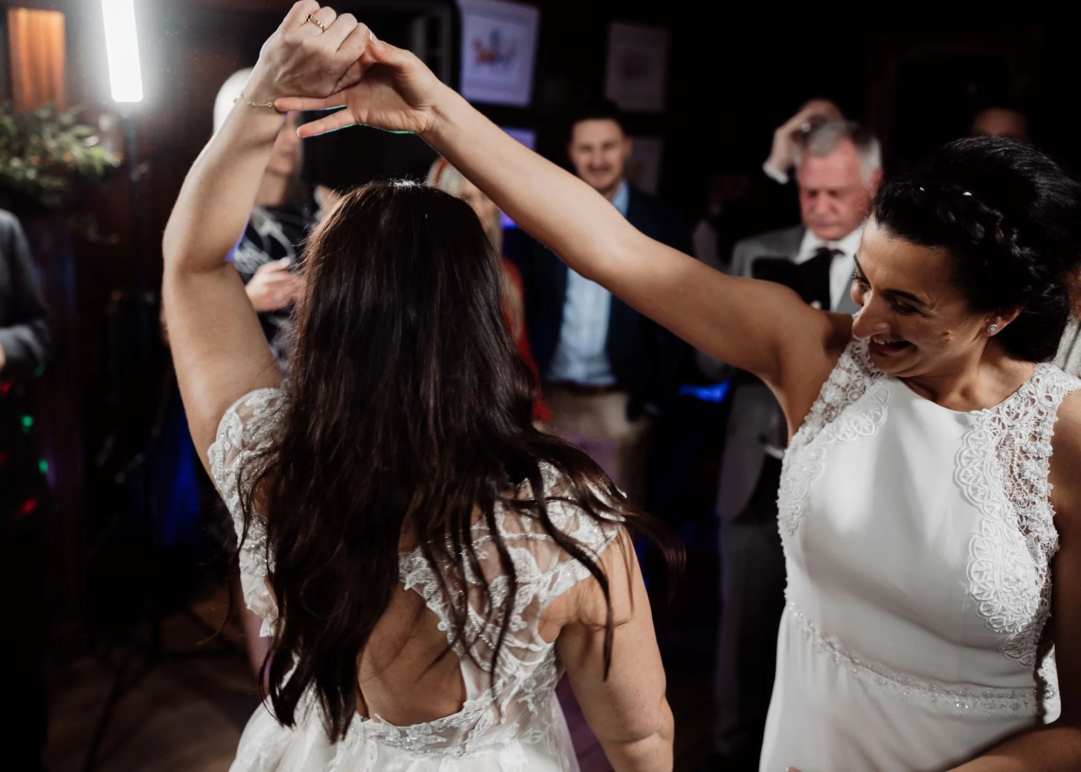 Newlyweds dancing joyfully during their wedding reception at Lanwades Hall, Suffolk, surrounded by guests enjoying the evening celebration
