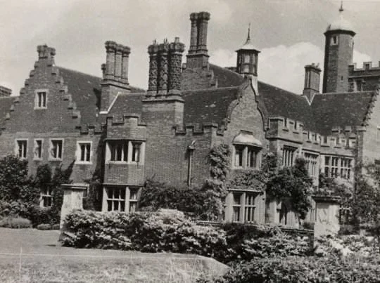 Historic exterior view of Lanwades Hall showing decorative chimneys and Edwardian-style architecture.