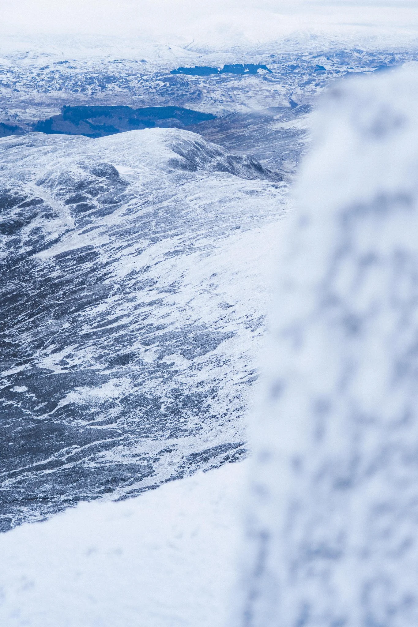 Snow-covered mountains and valleys in a cold, icy landscape.