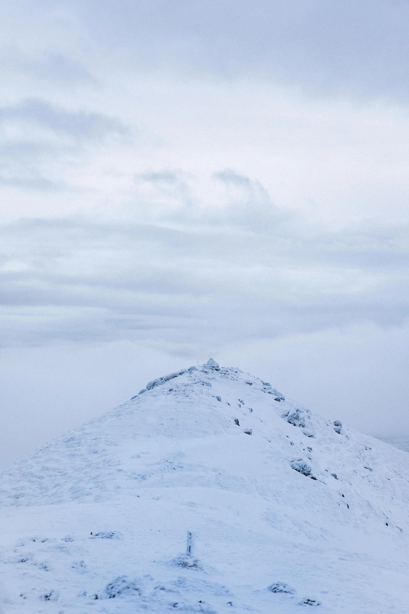 Snow-covered mountain peak under a cloudy sky.