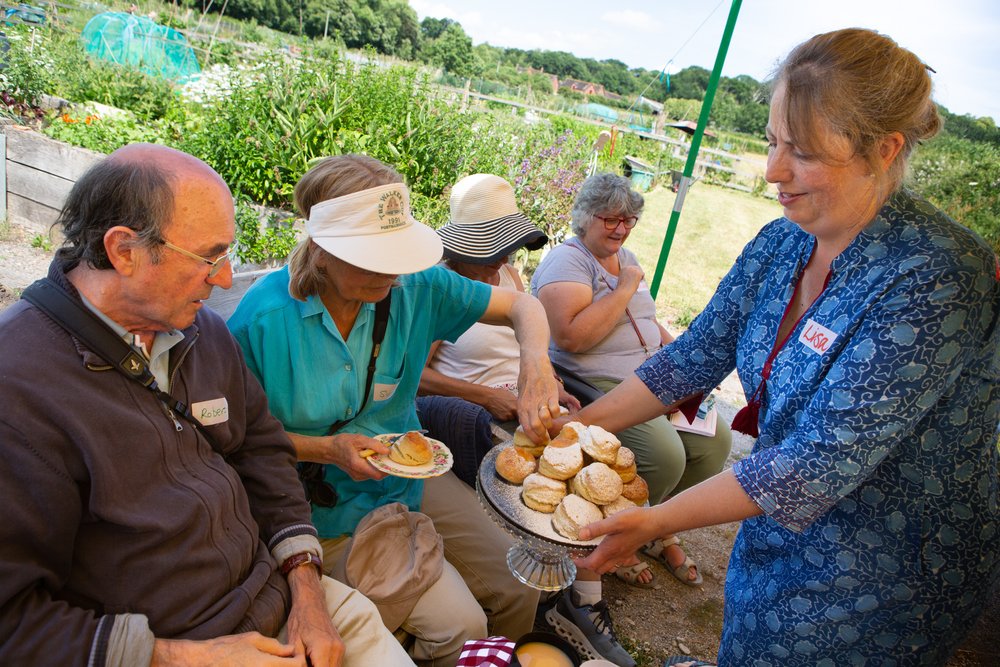 In Jolly Good Company - Cream Tea at the allotment - Lisa serving the scones.jpg