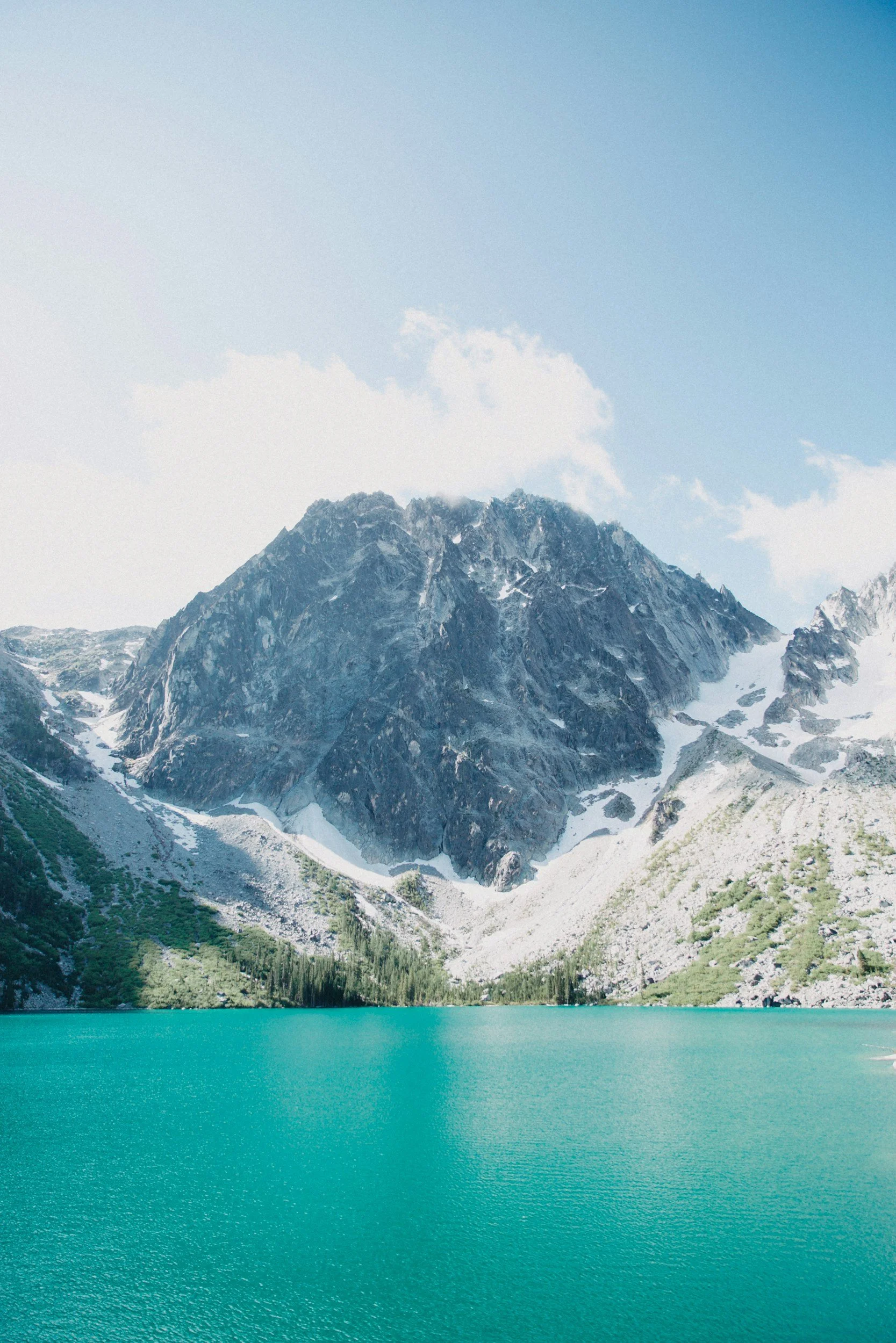 snowy mountain rising out of turquoise water