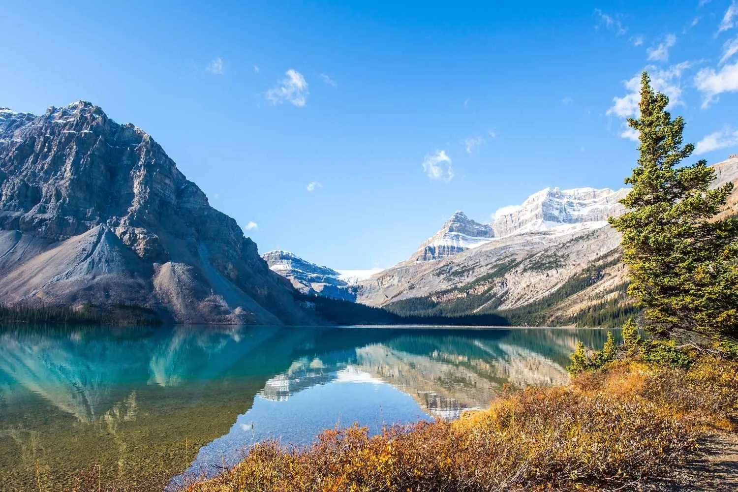 Calm clear water at the foot of a rocky mountain