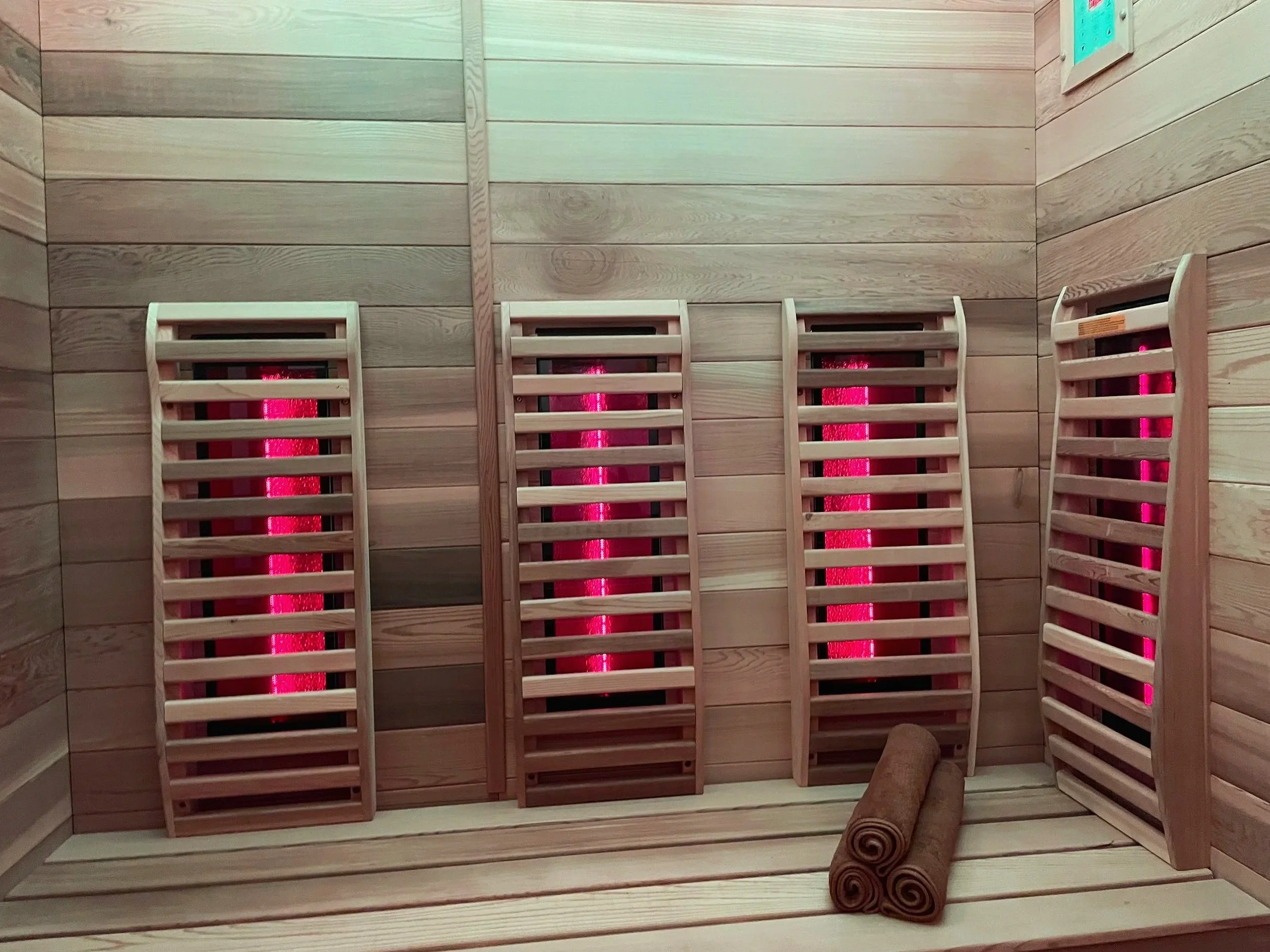 Binnenkant van een infraroodsauna met houten banken en verwarmingselementen  bij Shemaiah Beauty & Wellness in Amstelveen