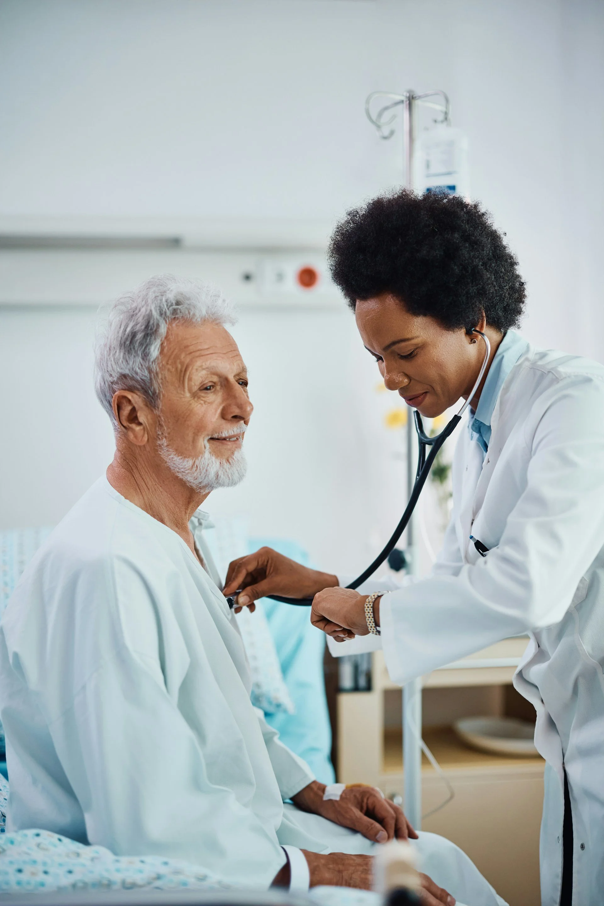 A caregiver checks her patients heart with a stethoscope