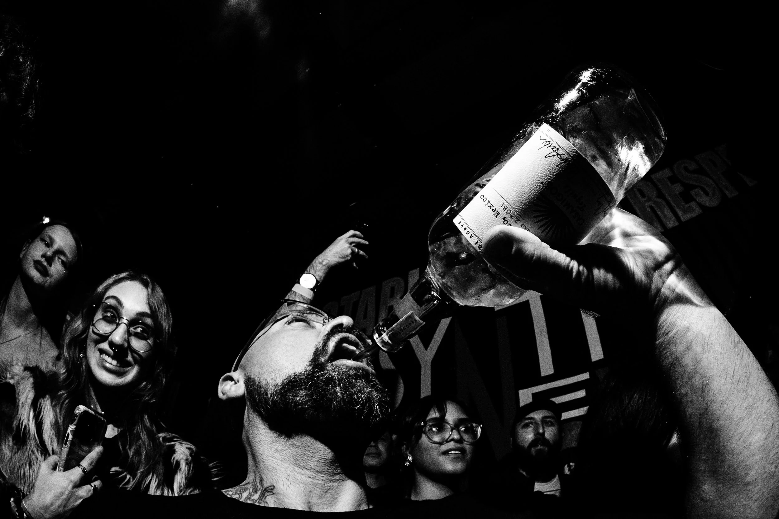 Taken during a 2025 performance by the band Daikaiju. A bartender waded through a  sea of people to hand a bottle of tequila to the lead guitarist of the band, who then proceeded to pour it into the mouths of everyone standing nearby and his own mout