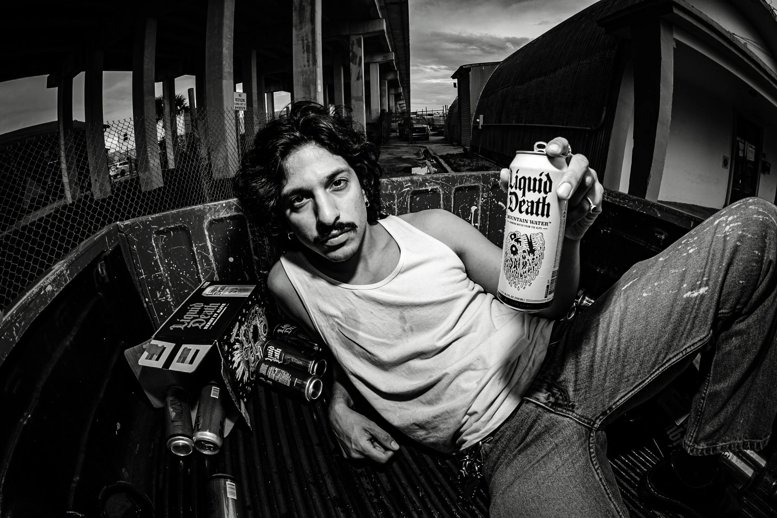An acquaintance of mine, José, was an aspiring model, doing a shoot together I noticed he had several cases of Liquid Death in the cab of his truck. We decided to do some photos as if he "had too much to drink" and passed out in his truck bed. 

Abou