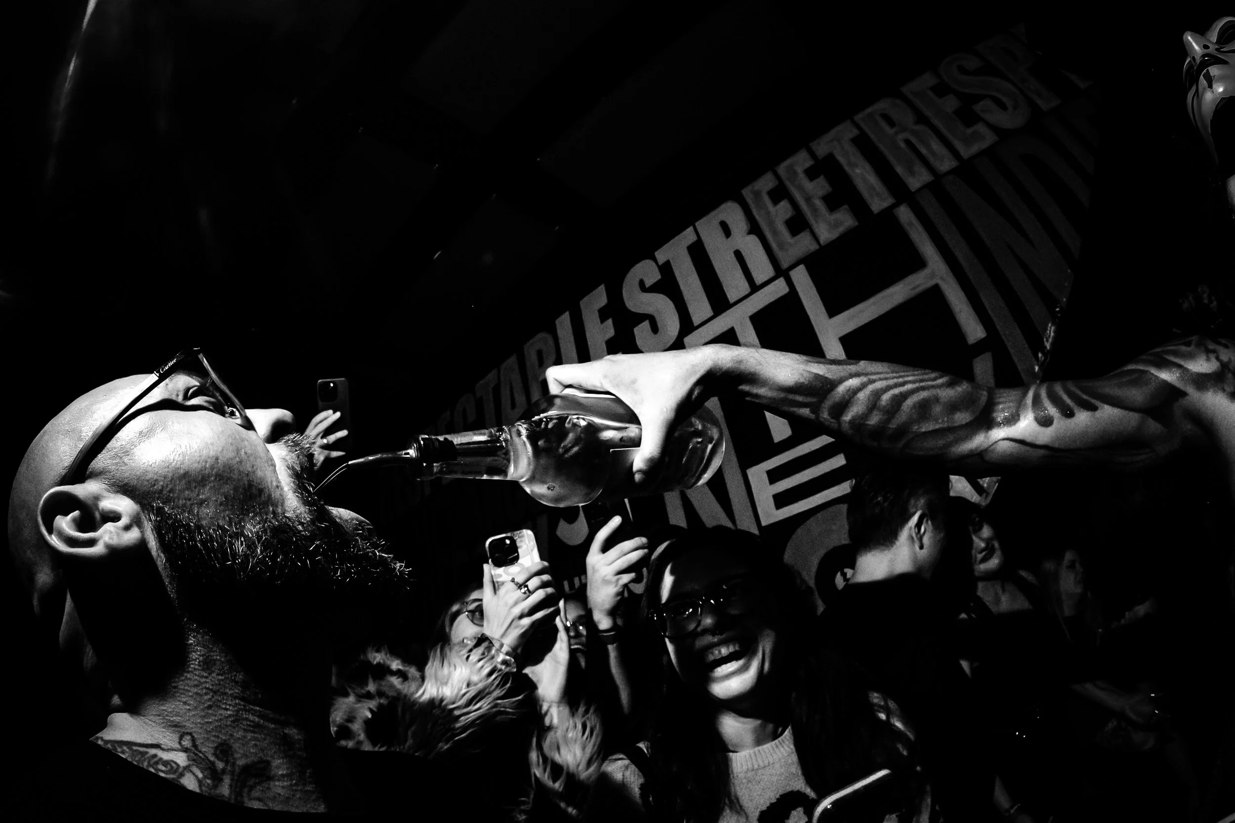 Taken during a 2025 performance by the band Daikaiju. A bartender waded through a  sea of people to hand a bottle of tequila to the lead guitarist of the band, who then proceeded to pour it into the mouths of everyone standing nearby and his own mout