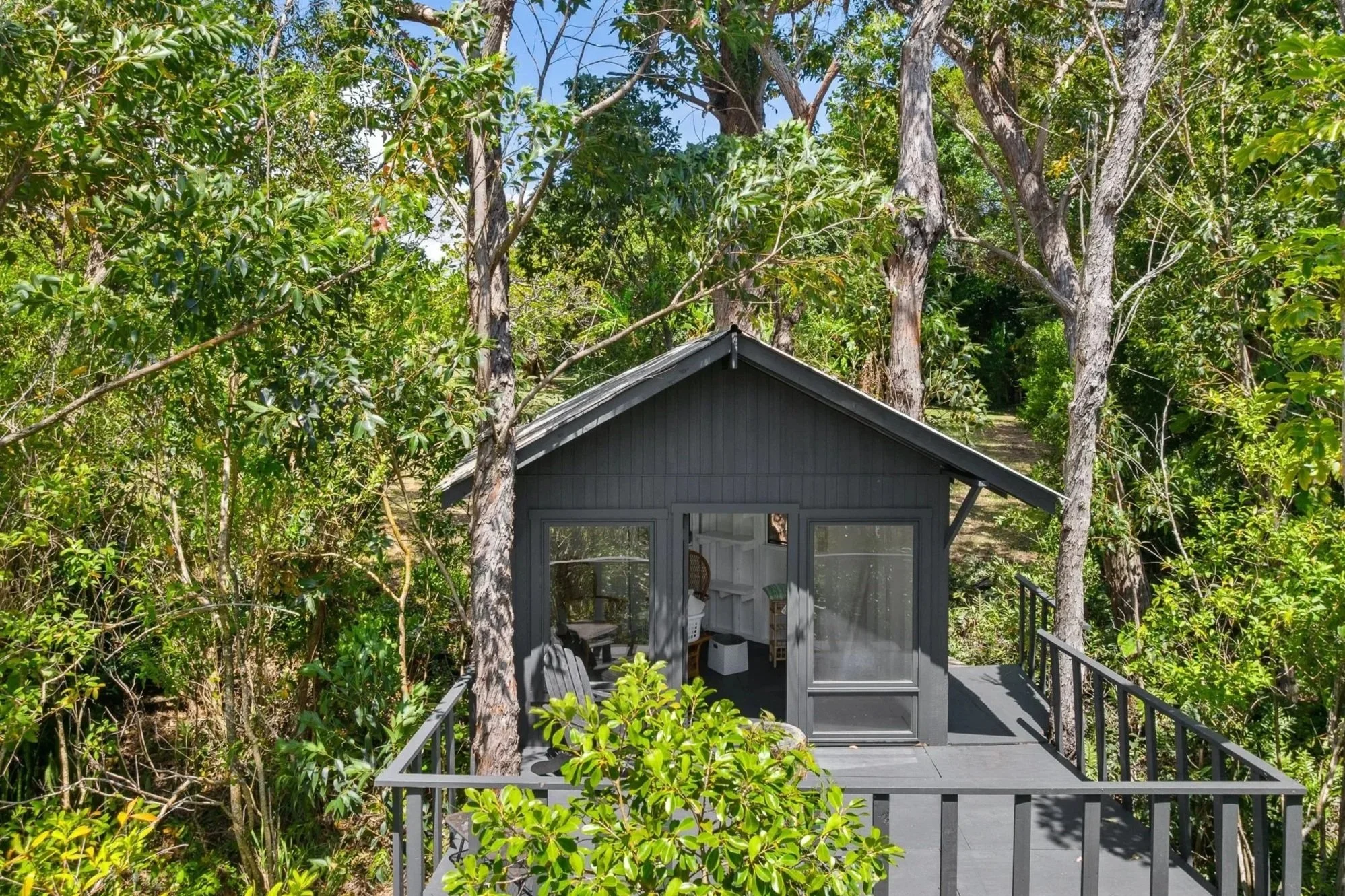 Private treehouse surrounded by lush tropical vegetation on a Haiku, Maui estate, presented by Eva Besselmann.