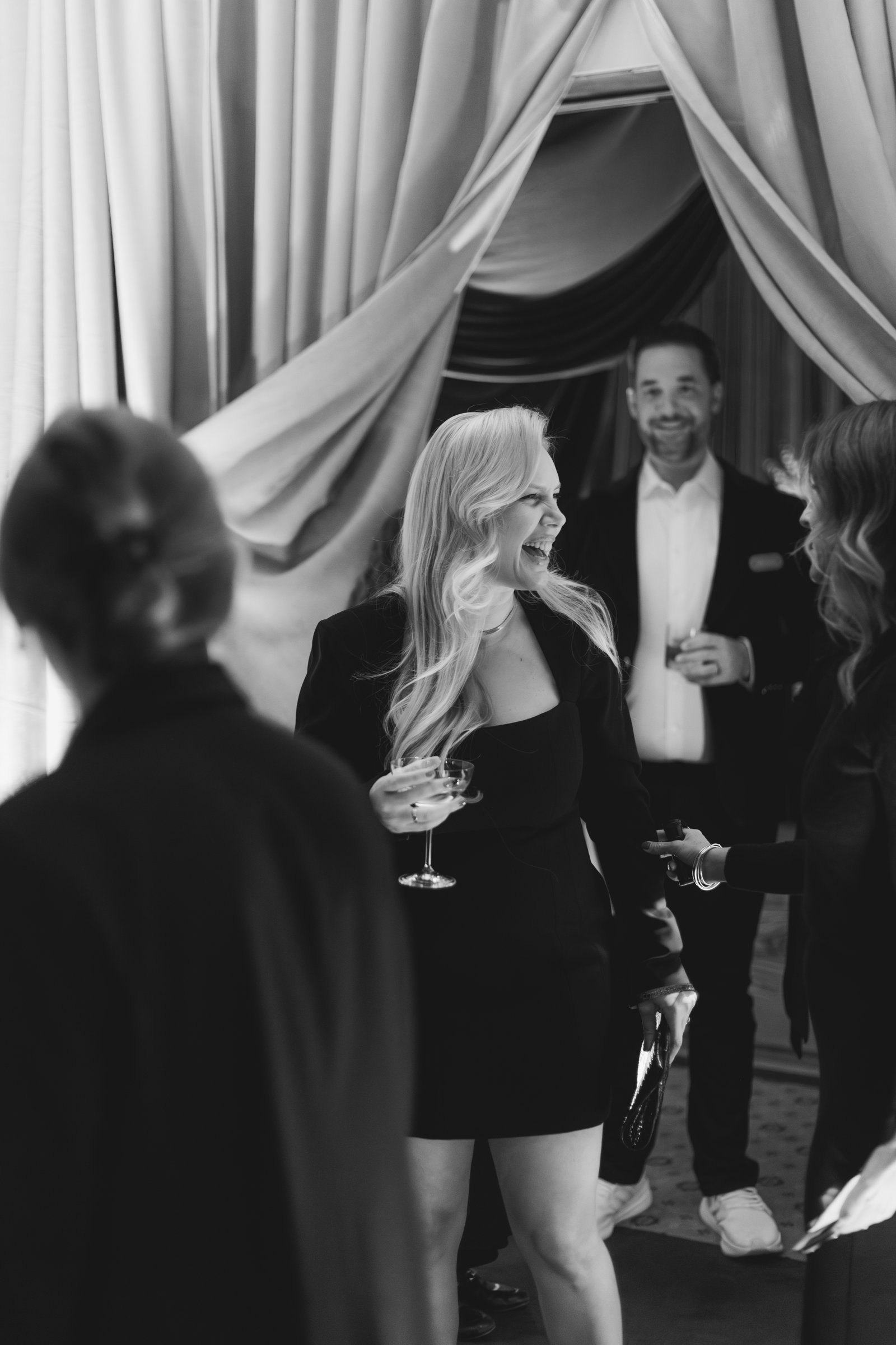 bash-please-utah-investor-community-summit-black-and-white-welcome-party-guests-champagne-coupe-velvet-drapery-entrance.jpg