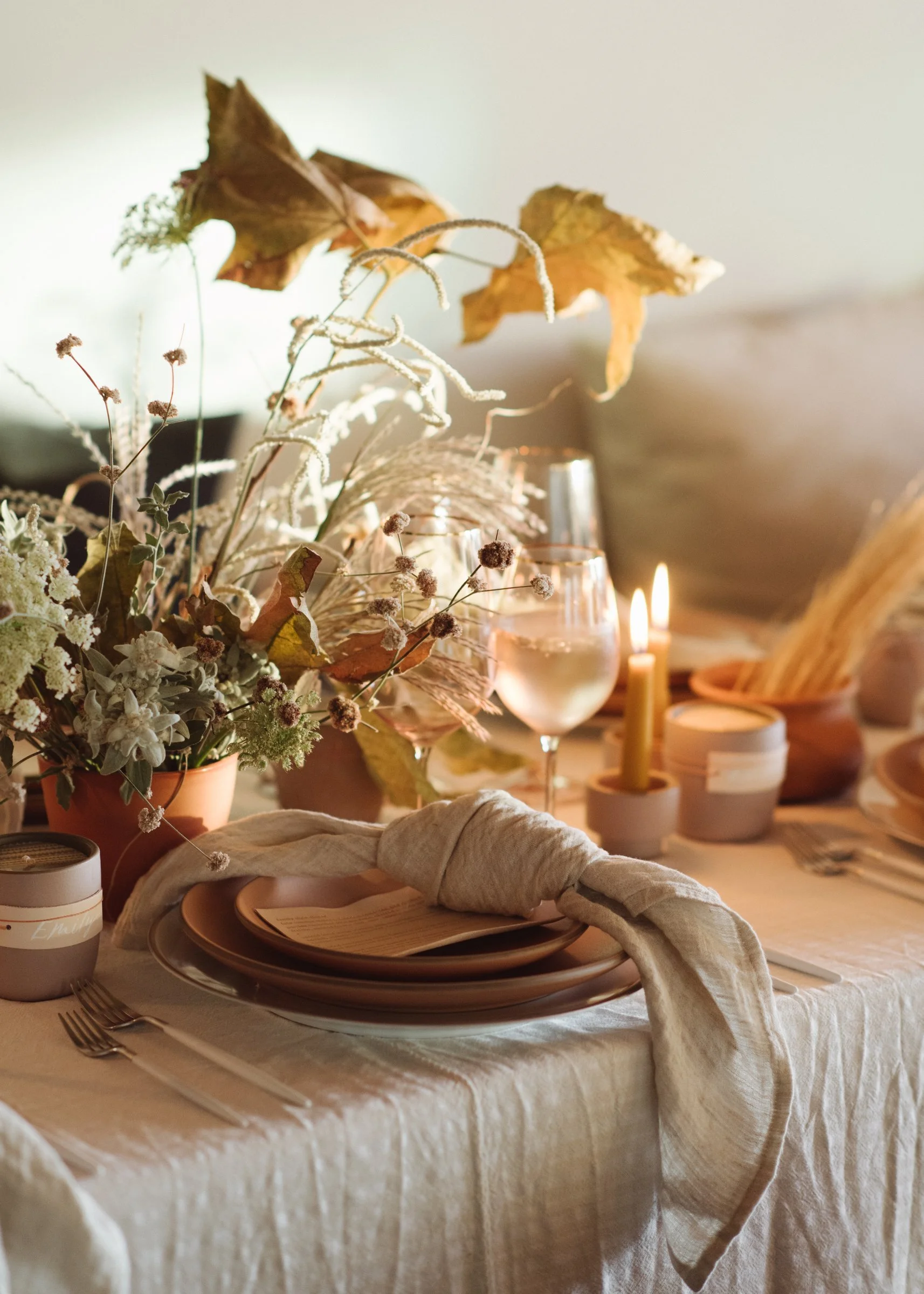 norman-and-blake-launch-gathering-los-angeles-autumn-leaf-and-wildflower-centerpiece-terracotta-vessels-knotted-linen-napkin-place-setting.jpg