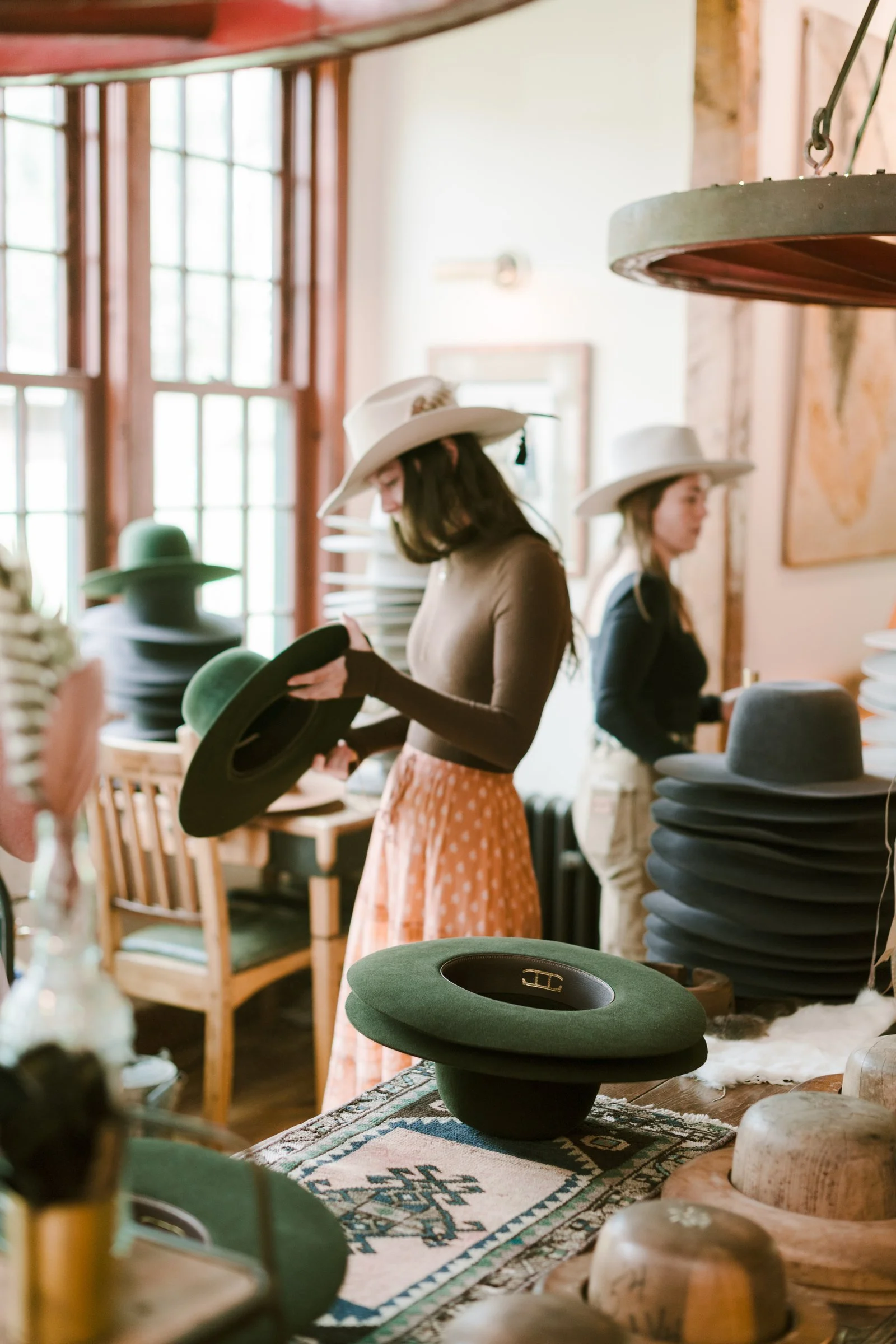 bash-please-dutton-hot-springs-corporate-retreat-guests-selecting-custom-felt-hats-high-end-corporate-event-planning-and-design.jpg