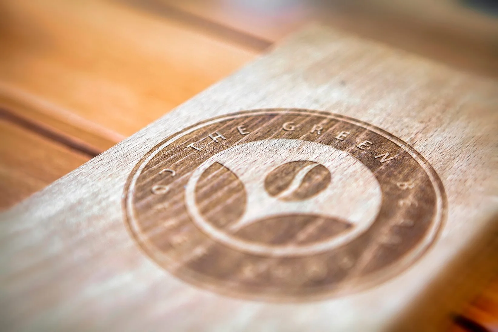 Close-up of a wooden surface engraved with a smiley face and the words "THE GOOD LIFE" around it.