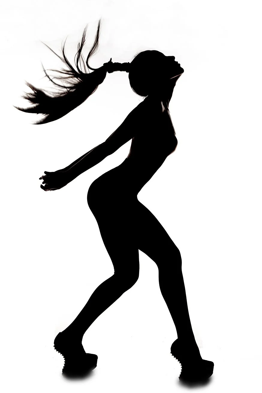 Silhouette of a woman with long flowing hair dancing or posing in high-heeled shoes.