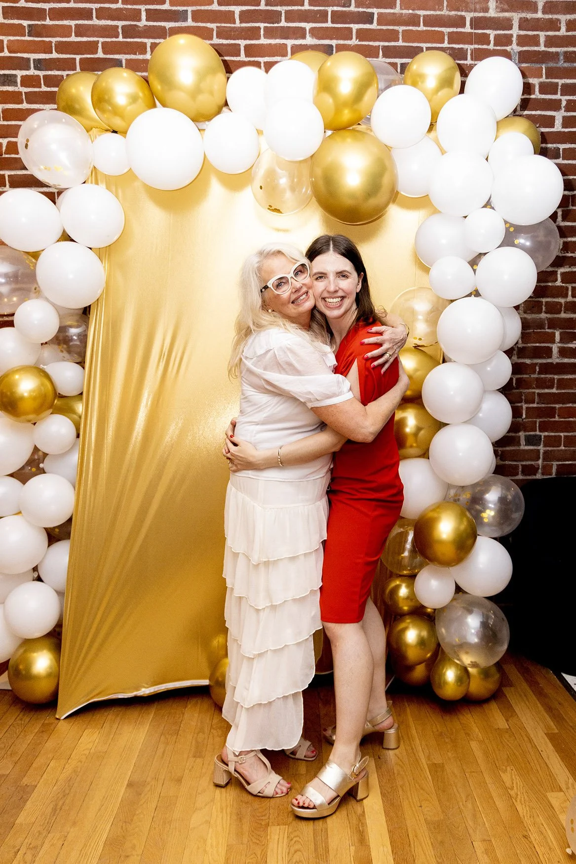 Me and my daughter embracing in front of balloons.