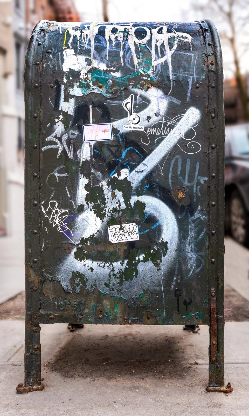 Fine art urban photography print of a public New York City mailbox covered in sticker slaps and graffiti. This photograph of street art collage is captured by contemporary photographer Barton Lewis.