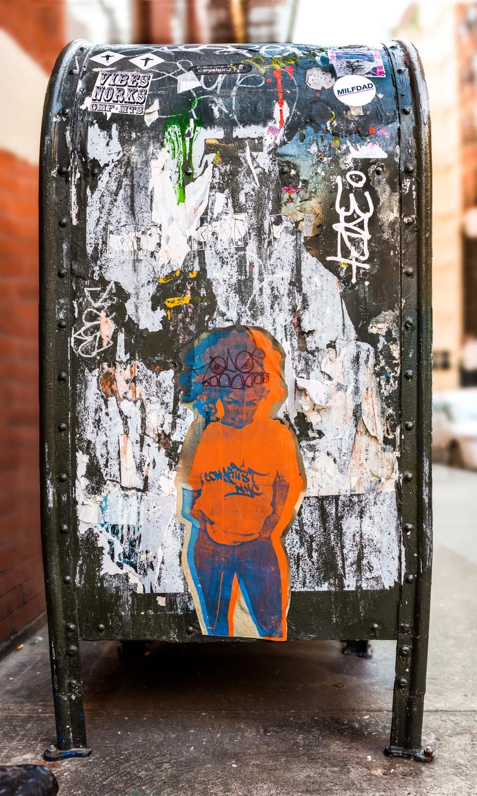 Fine art urban photography print of a public New York City mailbox covered in sticker slaps and graffiti. This photograph of street art collage is captured by contemporary photographer Barton Lewis.