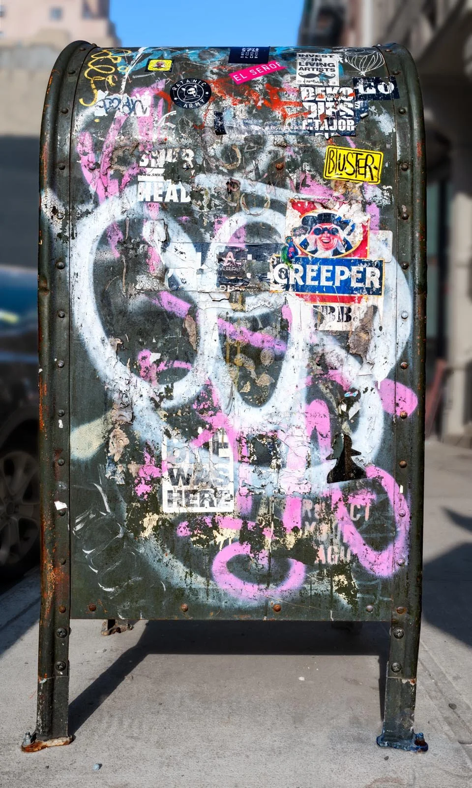Fine art urban photography print of a public New York City mailbox covered in sticker slaps and graffiti. This photograph of street art collage is captured by contemporary photographer Barton Lewis.