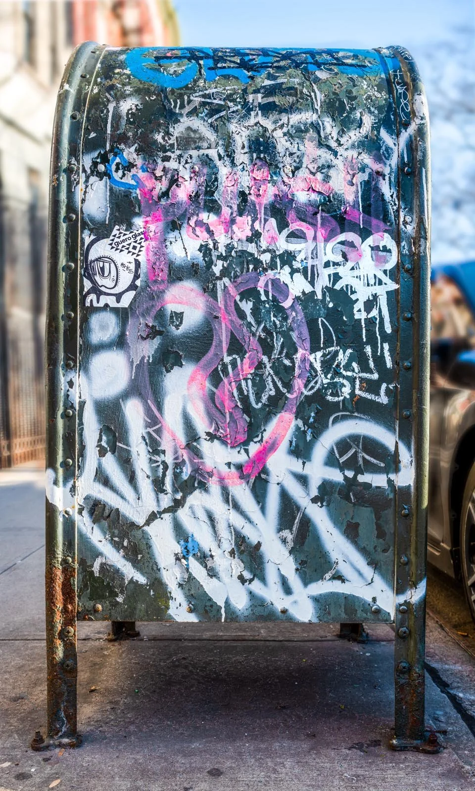 Fine art urban photography print of a public New York City mailbox covered in sticker slaps and graffiti. This photograph of street art collage is captured by contemporary photographer Barton Lewis.